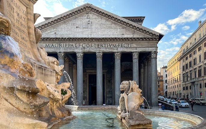 Pantheon facade in Rome with fountain in foreground.