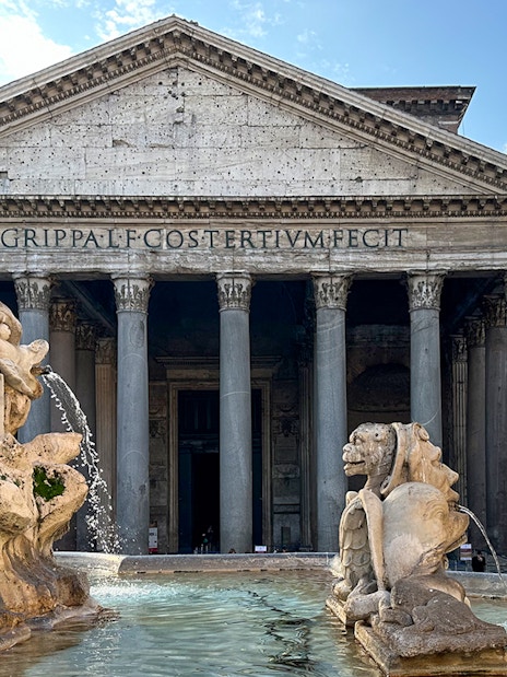 Pantheon facade in Rome with fountain in foreground.