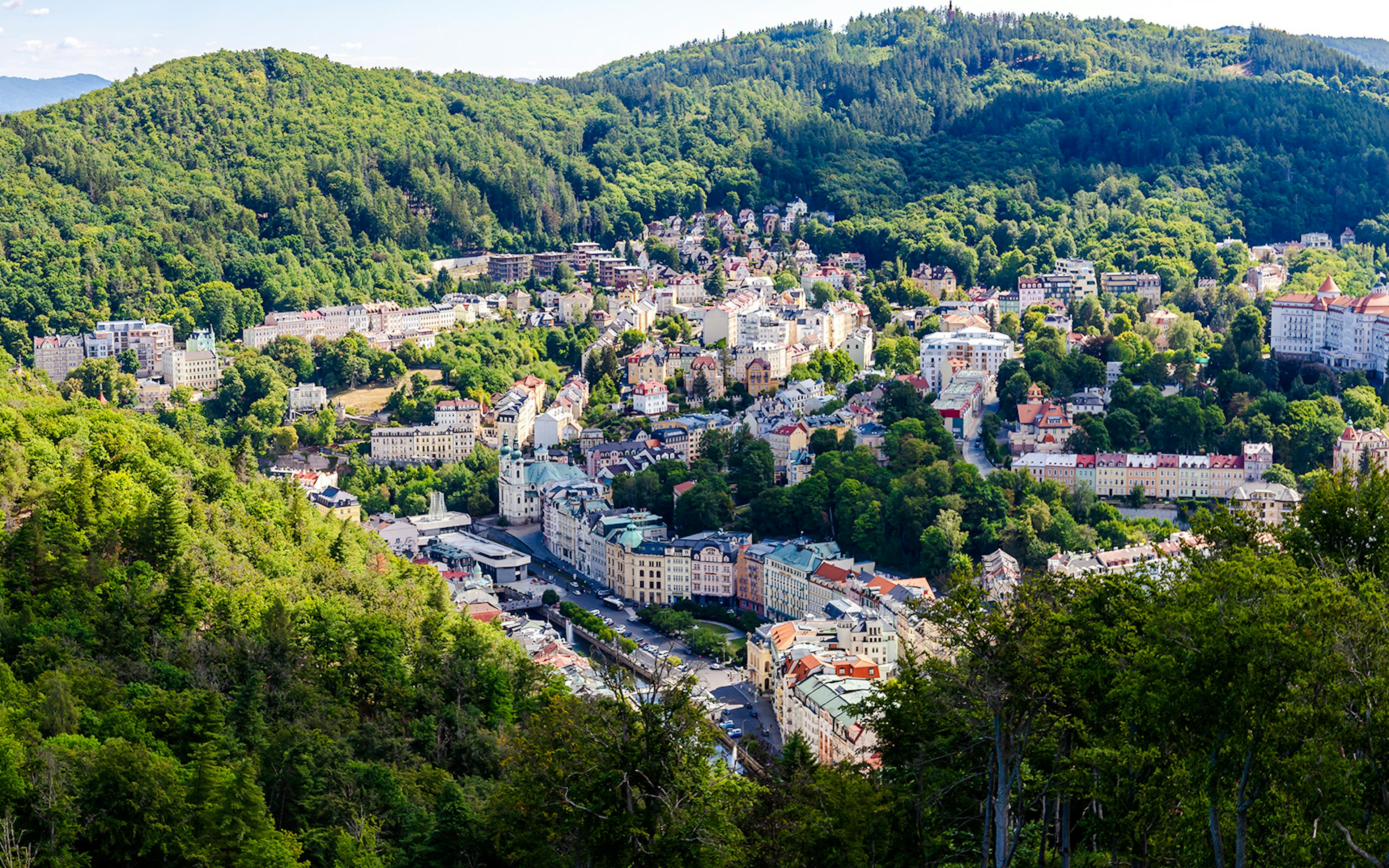 View of Karlovy Vary, Czech Republic, surrounded by lush forests from Diana Observation Tower.