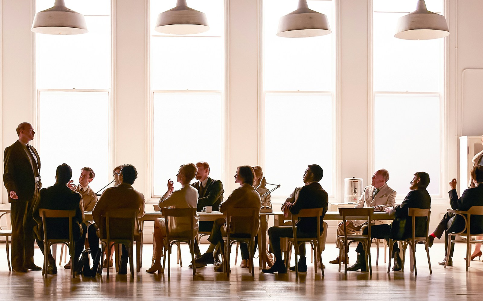 Group of people in a meeting room, one person standing and speaking, related to "The Motive and the Cue.