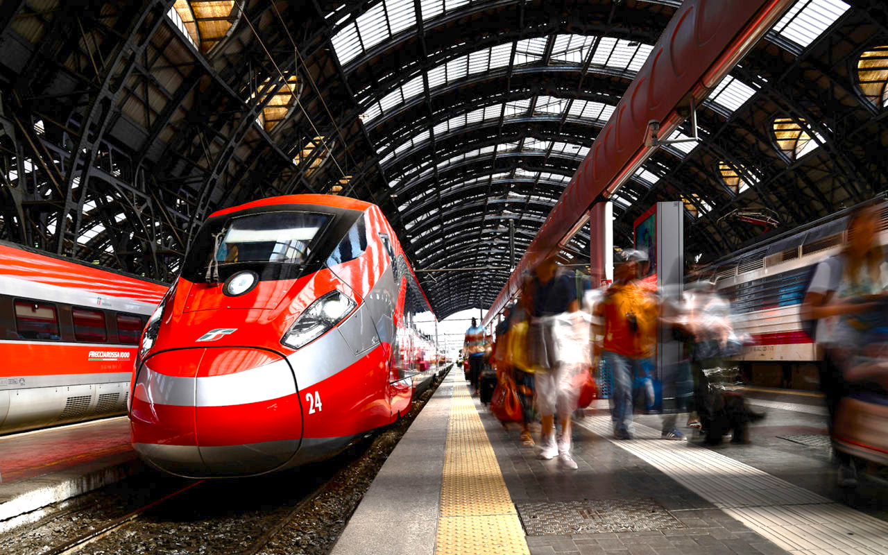 Trenitalia Frecciarossa train at a bustling station platform.