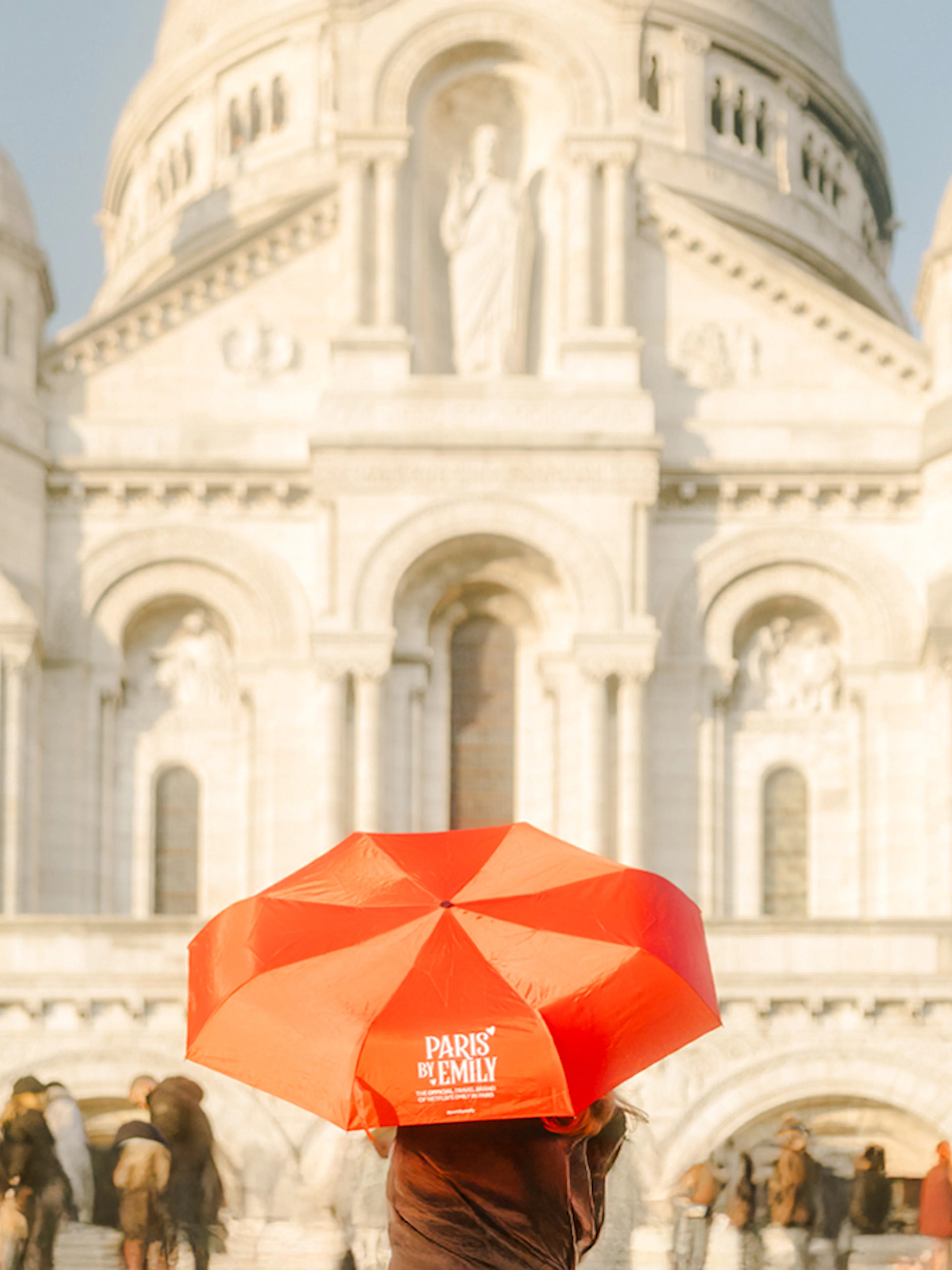 Sacre-Coeur Basilica with tourists and a red umbrella on the Emily in Paris Montmartre Walking Tour.