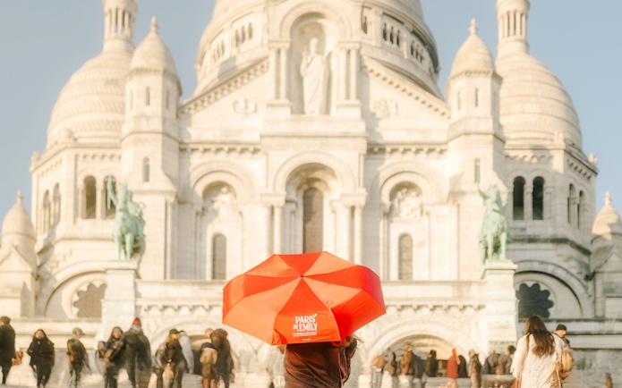 Sacre-Coeur Basilica with tourists and a red umbrella on the Emily in Paris Montmartre Walking Tour.