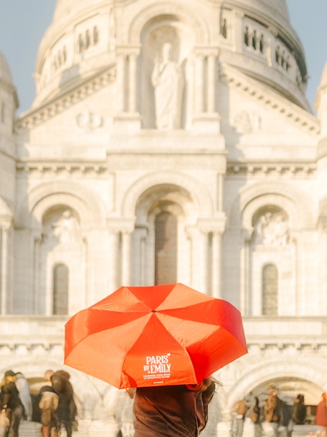 Sacre-Coeur Basilica with tourists and a red umbrella on the Emily in Paris Montmartre Walking Tour.