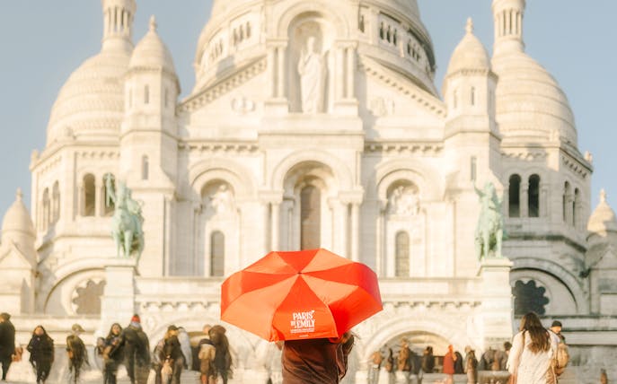 Sacre-Coeur Basilica with tourists and a red umbrella on the Emily in Paris Montmartre Walking Tour.