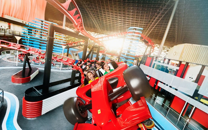 Roller coaster ride at Ferrari World, Yas Island, Abu Dhabi, with visitors enjoying the thrill.