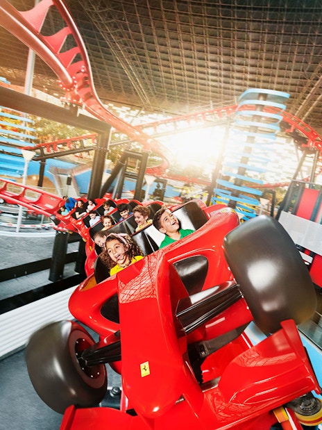 Roller coaster ride at Ferrari World, Yas Island, Abu Dhabi, with visitors enjoying the thrill.
