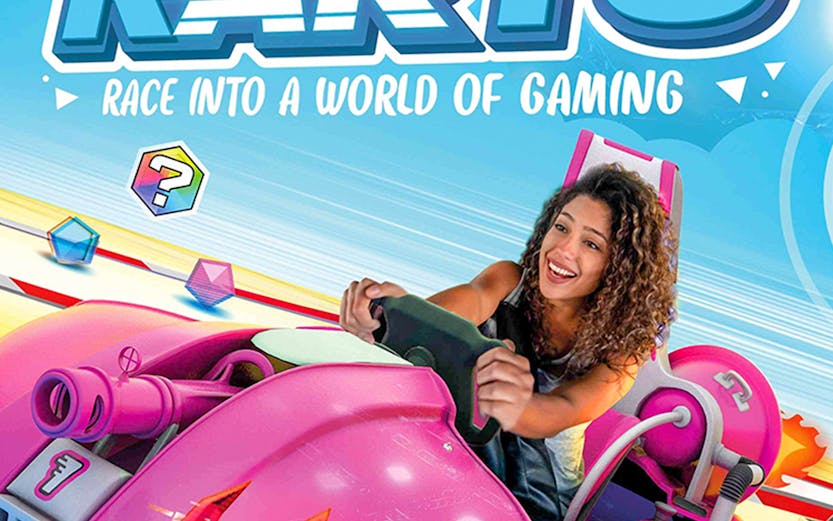 Person driving a pink go-kart at Chaos Karts Dubai, with vibrant gaming graphics.