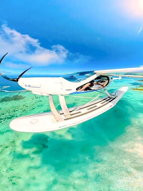Seaplane flying over turquoise waters near Mauritius on the Scenic Seaplane Tour.
