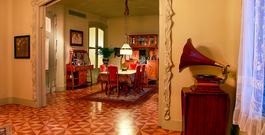 Casa Mila fourth-floor apartment dining room with vintage decor and gramophone.