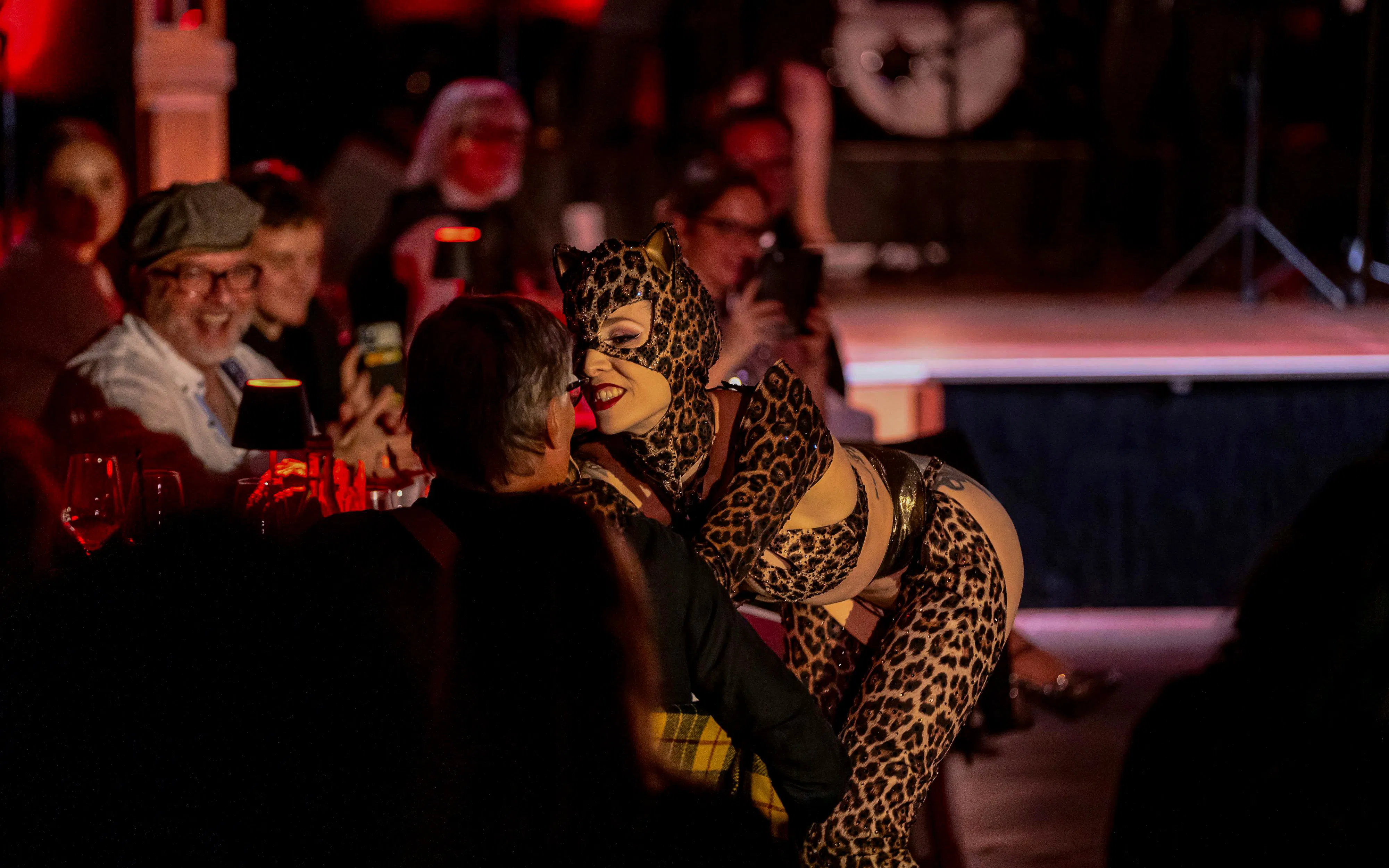 Performer in leopard costume interacting with audience at The Mirage dinner show, Vienna.