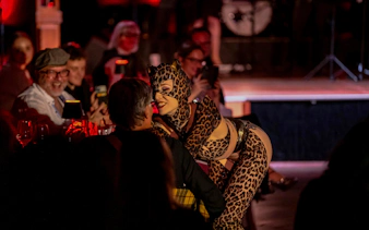 Performer in leopard costume interacting with audience at The Mirage dinner show, Vienna.