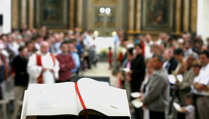 Chanting inside Notre Dame Cathedral, Paris, with intricate stained glass windows.
