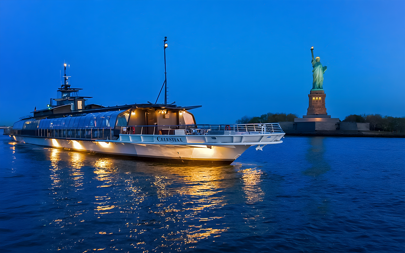 Bateaux Premier Dinner Cruise near Statue of Liberty at dusk.