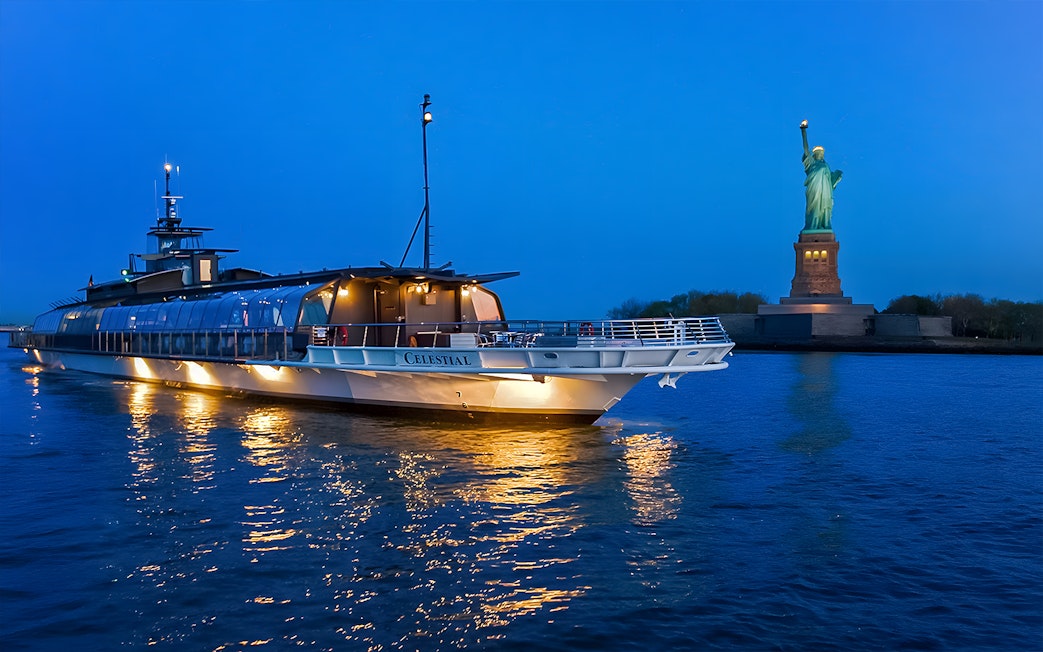 Bateaux Premier Dinner Cruise near Statue of Liberty at dusk.