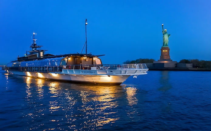 Bateaux Premier Dinner Cruise near Statue of Liberty at dusk.