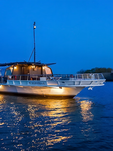 Bateaux Premier Dinner Cruise near Statue of Liberty at dusk.