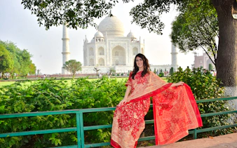 Visitor in traditional attire at the Taj Mahal during sunrise, Agra tour.
