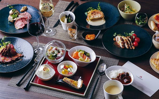 Japanese cuisine spread at Studio Ghibli Museum tour, featuring sushi, salads, and wine.