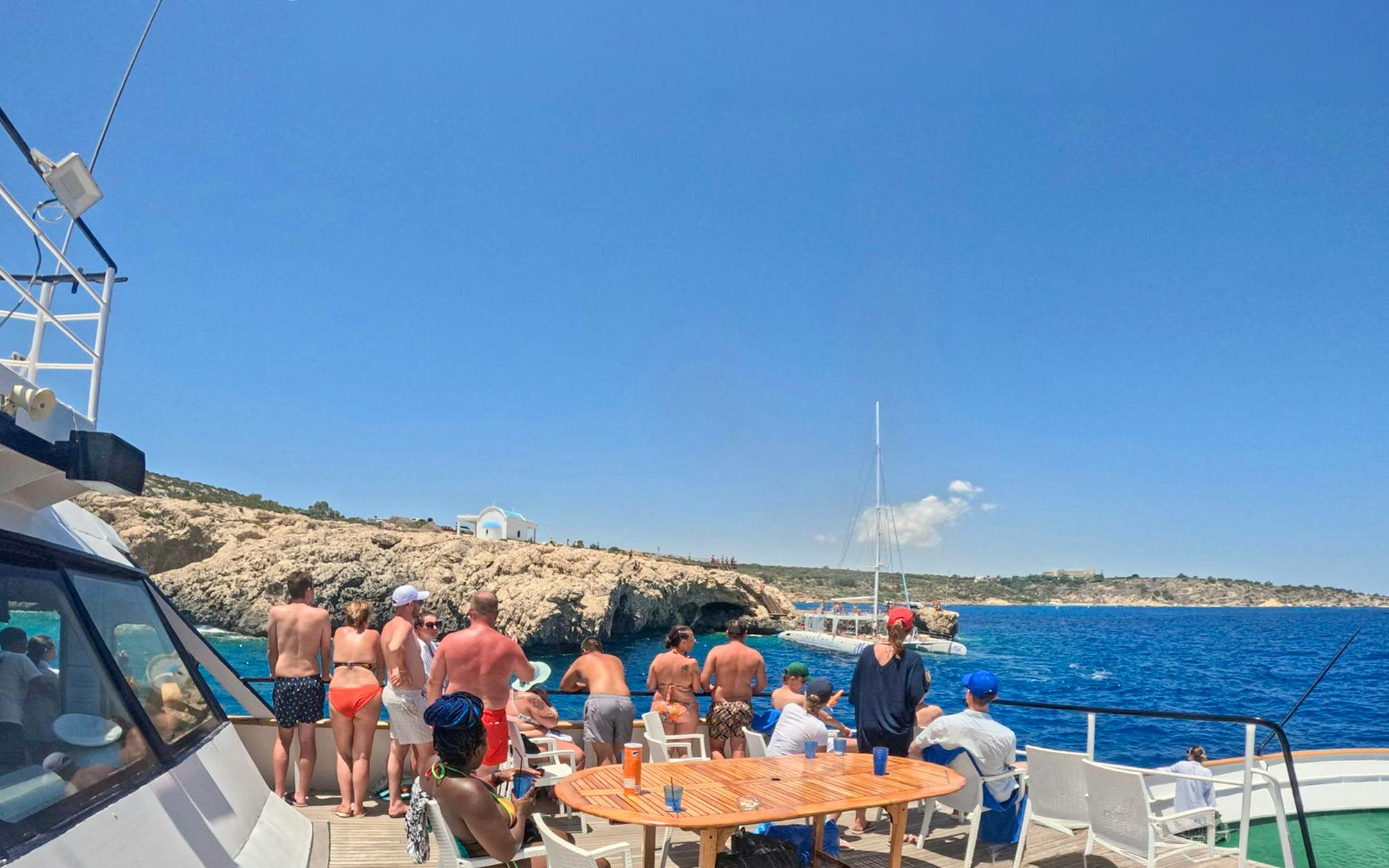 Tourists enjoying a Blue Lagoon cruise near rocky coastline in Larnaca, Cyprus.