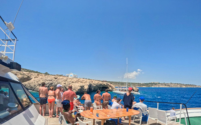 Tourists enjoying a Blue Lagoon cruise near rocky coastline in Larnaca, Cyprus.