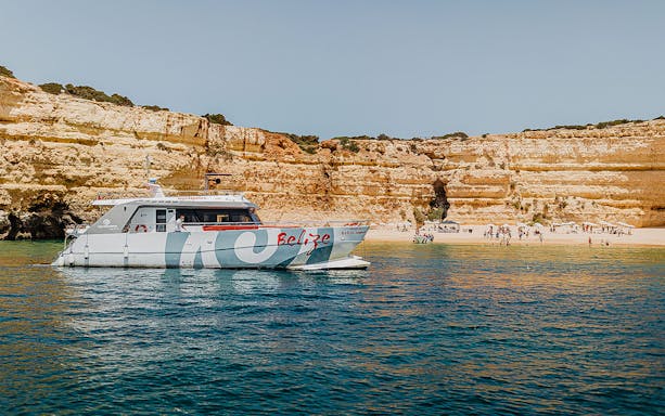 Catamaran near Albufeira beach with cliffs in the background, part of the Albufeira Cruise and Beach BBQ.