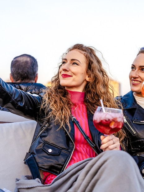 Guests taking selfies with drinks on Elegant Premium Sightseeing Cruise.