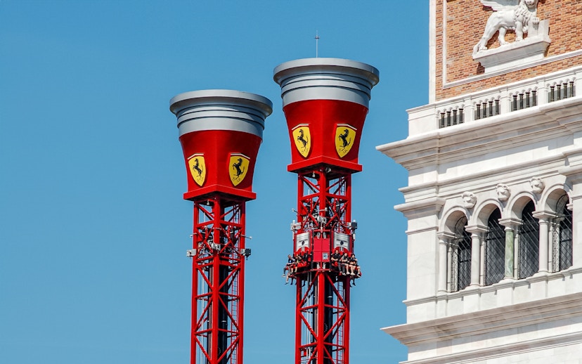 Thrill Towers ride at Ferrari Land with people ascending in red towers.