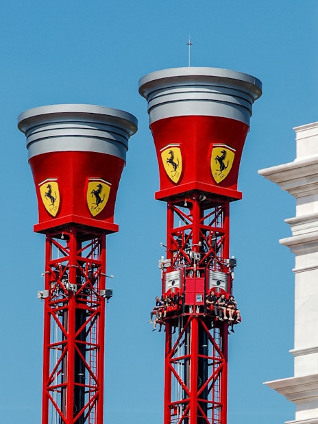 Thrill Towers ride at Ferrari Land with people ascending in red towers.
