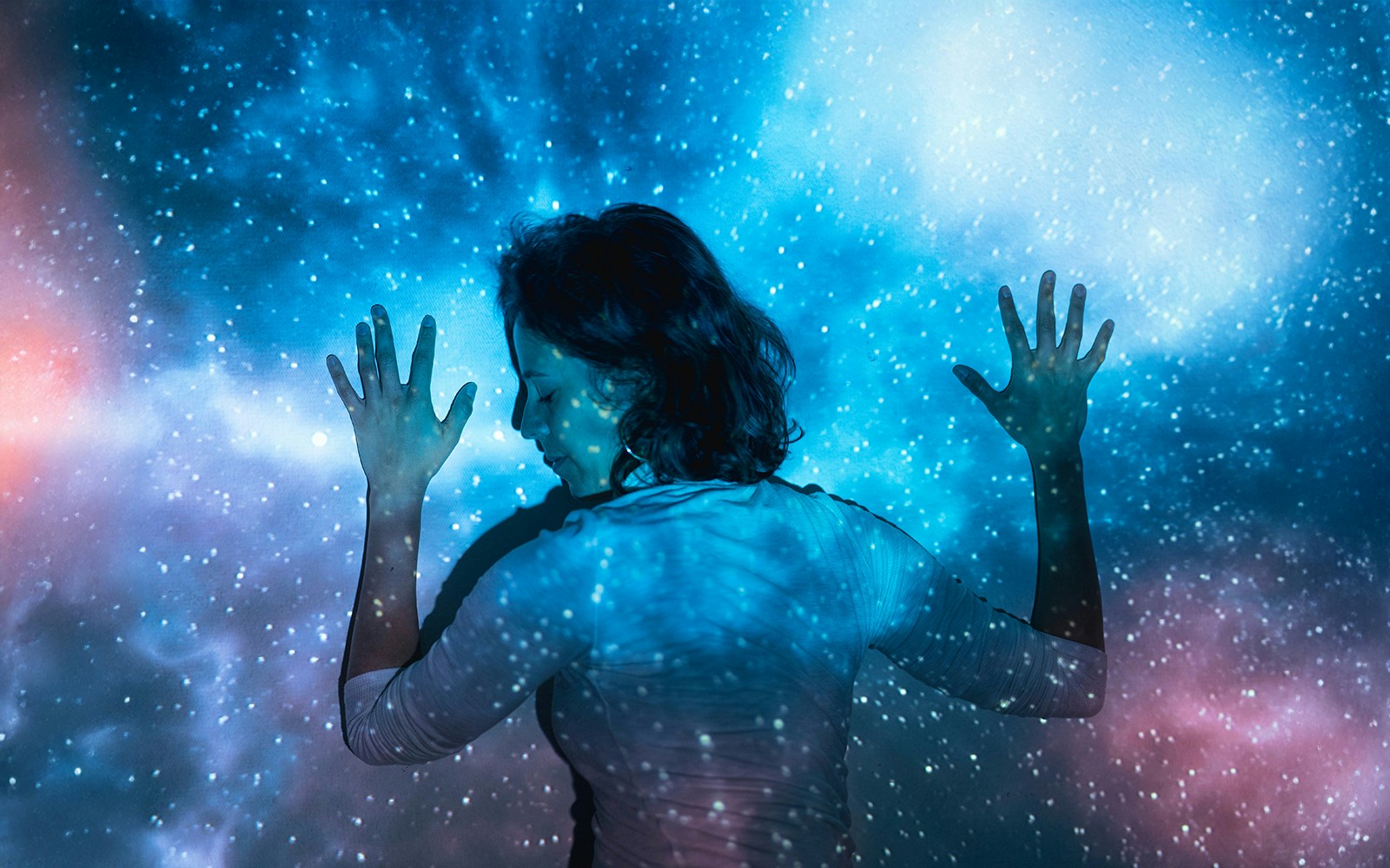 Person immersed in a cosmic light display at Illuminarium Experience, Las Vegas.