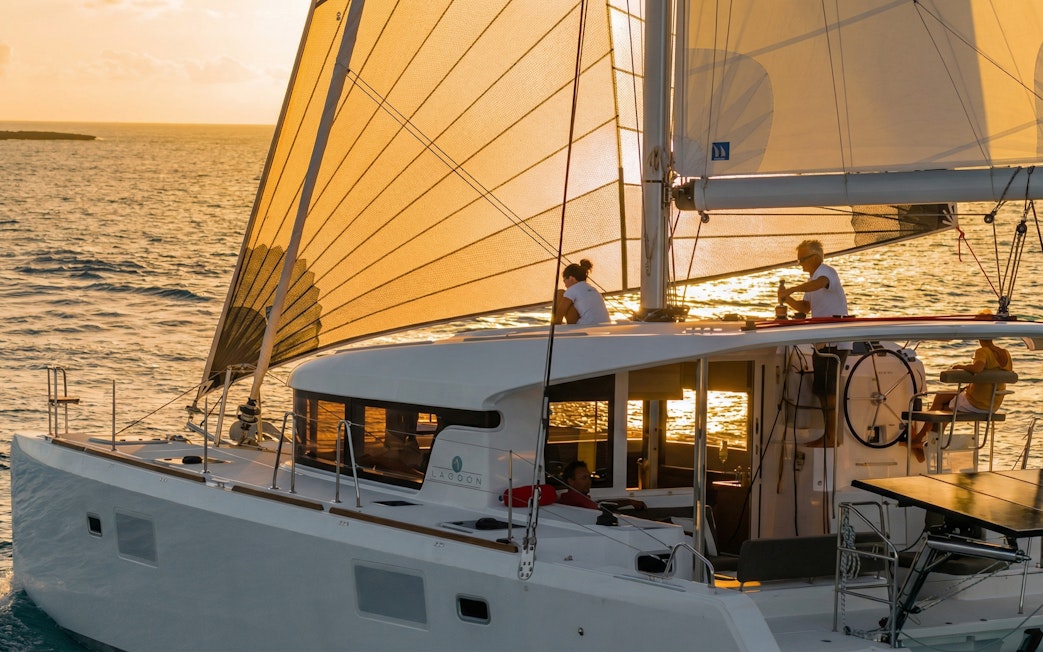 Catamaran sailing at sunset in La Maddalena, Italy.