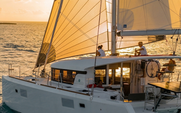 Catamaran sailing at sunset in La Maddalena, Italy.