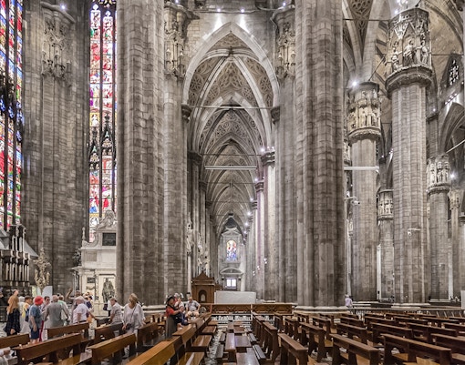 Intricate interiors of Duomo Cathedral in Milan showcasing ornate columns and detailed ceiling.