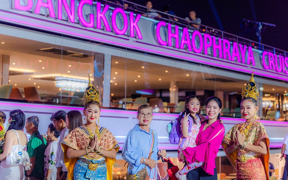 Performers in traditional attire on Bangkok Chaophraya Dinner Cruise with guests.