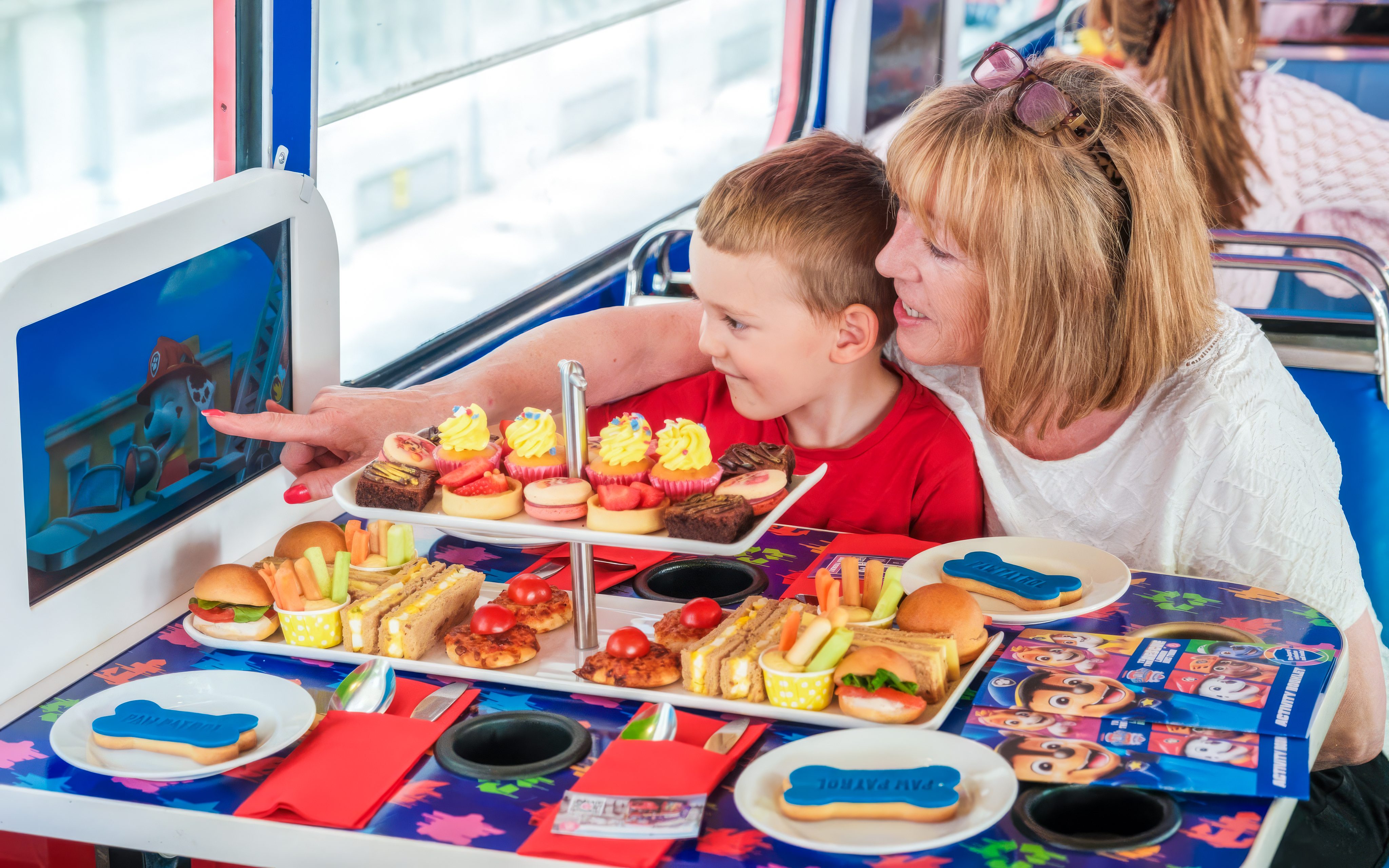 Kids and parents enjoying snacks aboard the Paw Patrol bus with themed table setting.