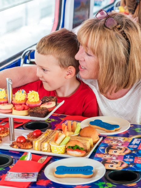 Kids and parents enjoying snacks aboard the Paw Patrol bus with themed table setting.