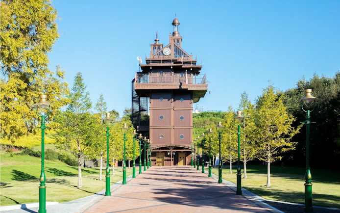 Elevator tower with clock and green lampposts in a landscaped park.