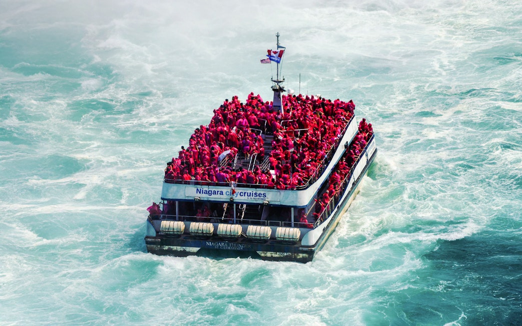 Tourists in red ponchos on a boat near Niagara Falls.