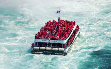 Tourists in red ponchos on a boat near Niagara Falls.