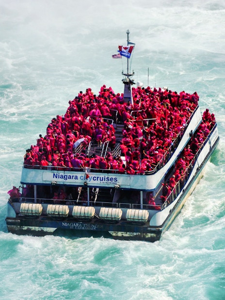 Tourists in red ponchos on a boat near Niagara Falls.