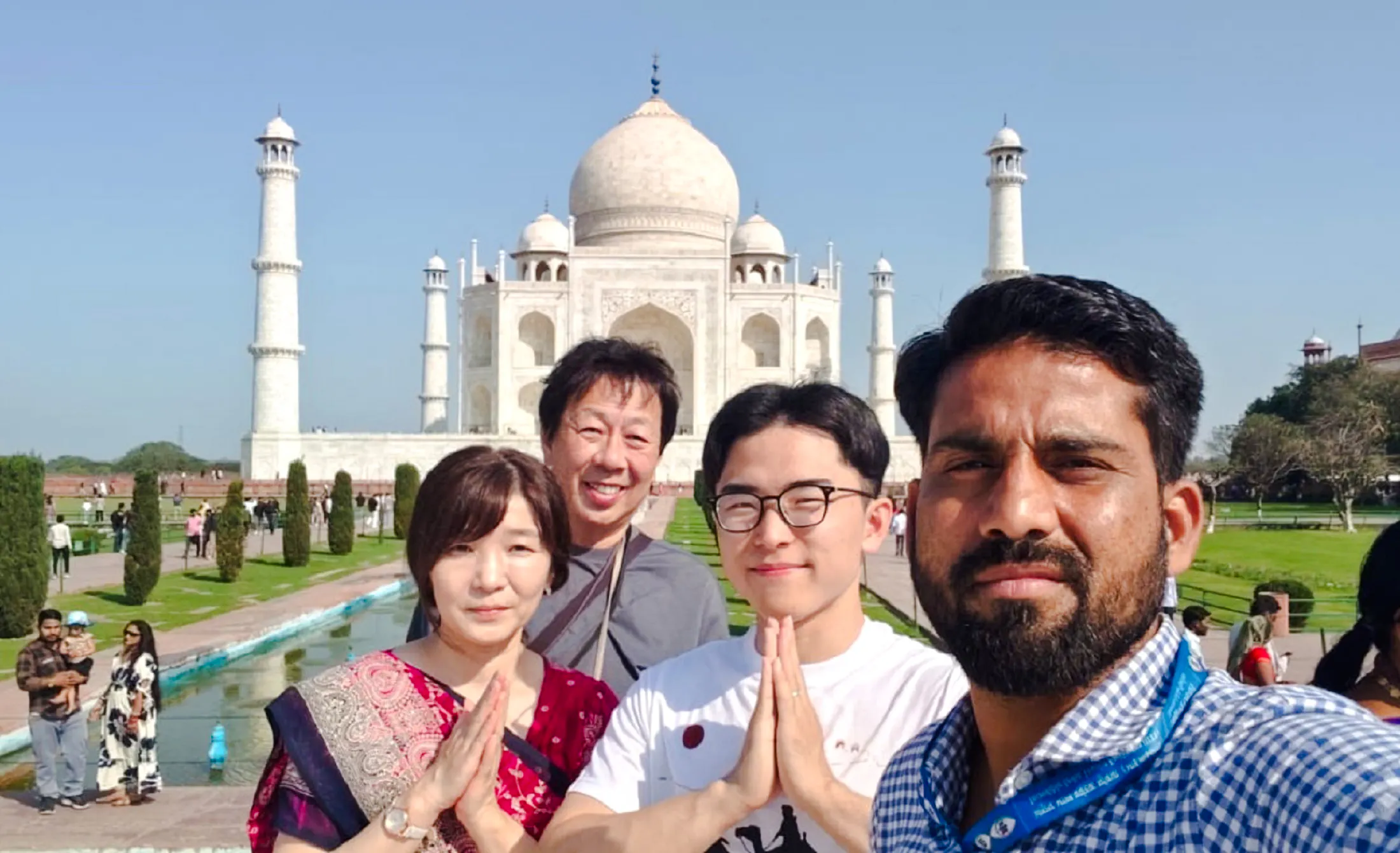Tourists posing in front of the Taj Mahal during a Delhi to Agra tour.