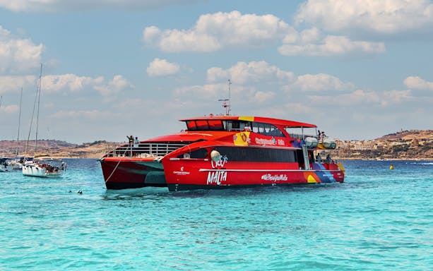 Red cruise boat on Gozo and Comino Blue Lagoon trip, Malta.