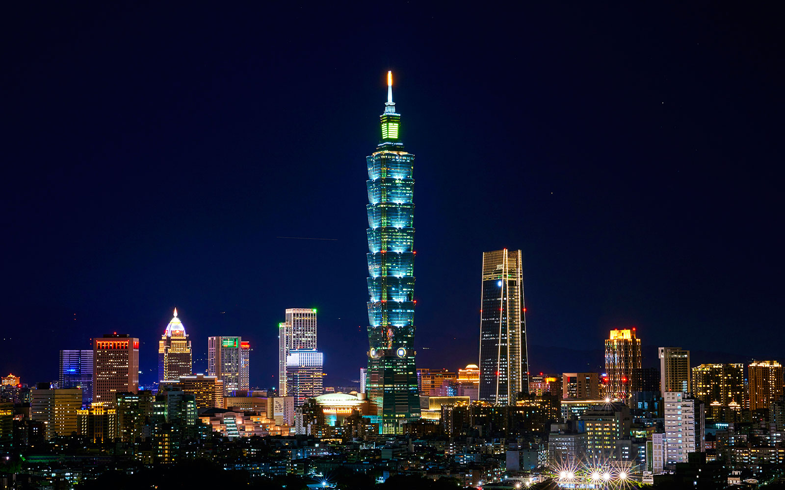 Taipei 101 illuminated at night, surrounded by cityscape in Taipei, Taiwan.