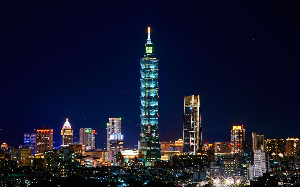 Taipei 101 illuminated at night, surrounded by cityscape in Taipei, Taiwan.