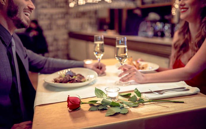 Couple enjoying dinner on Capitaine Fracasse Seine River cruise, Paris.