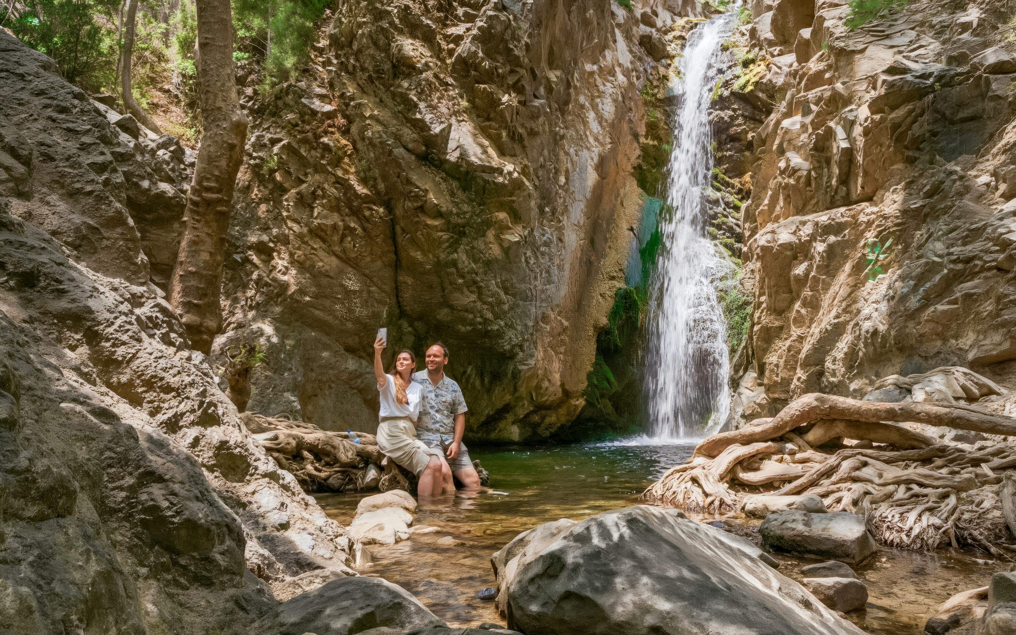 Couple taking a selfie by a waterfall in Troodos Mountains, Cyprus.