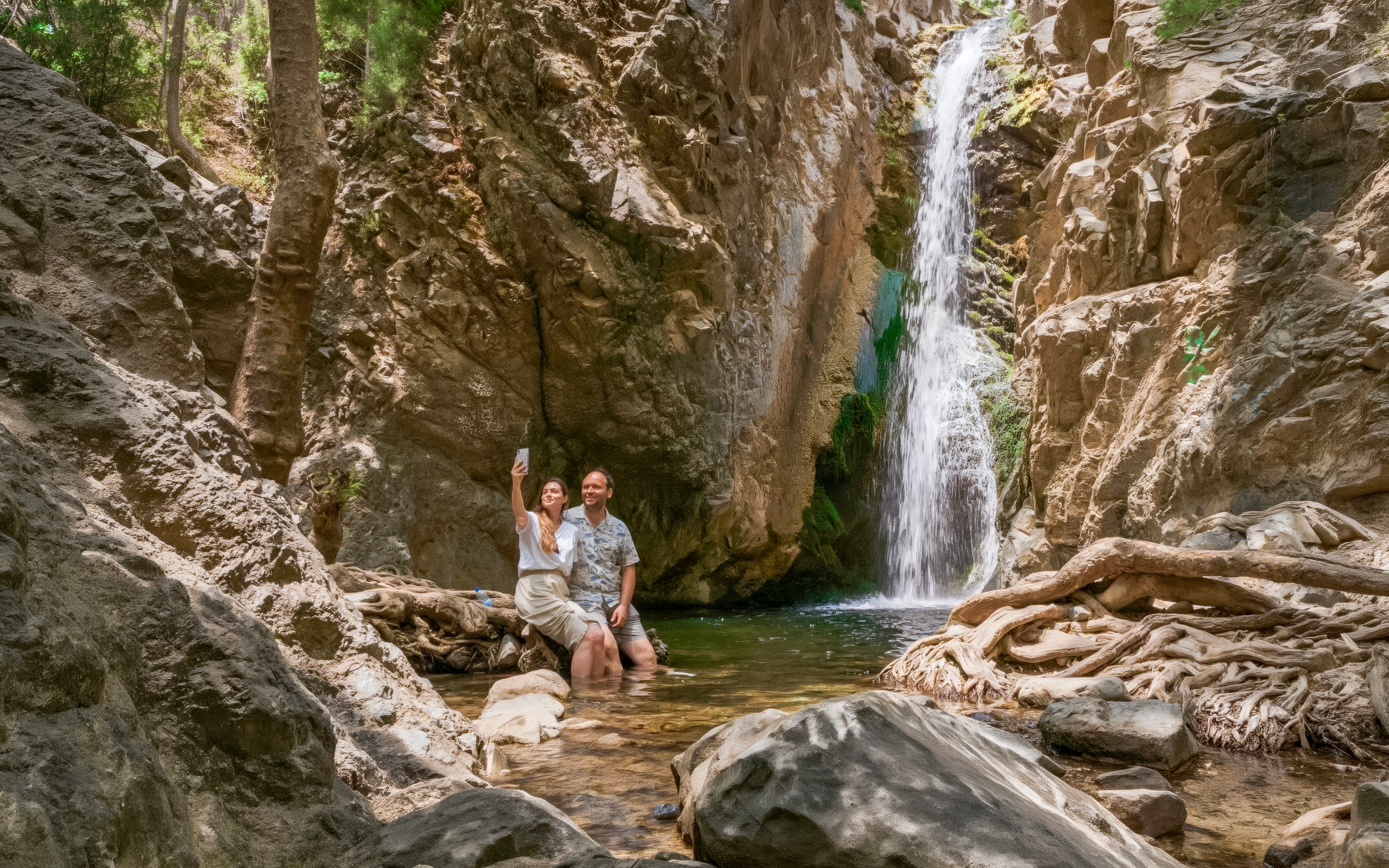 Couple taking a selfie by a waterfall in Troodos Mountains, Cyprus.
