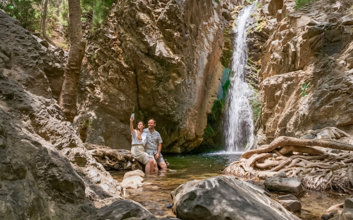 Couple taking a selfie by a waterfall in Troodos Mountains, Cyprus.