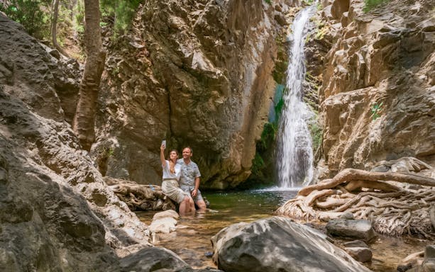 Couple taking a selfie by a waterfall in Troodos Mountains, Cyprus.