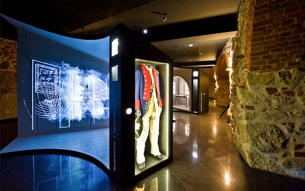 Exhibit of historical military uniform and digital map display inside Kościuszko Mound, Krakow.